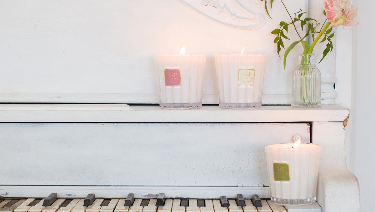 TOCCA candles sitting on top of a piano