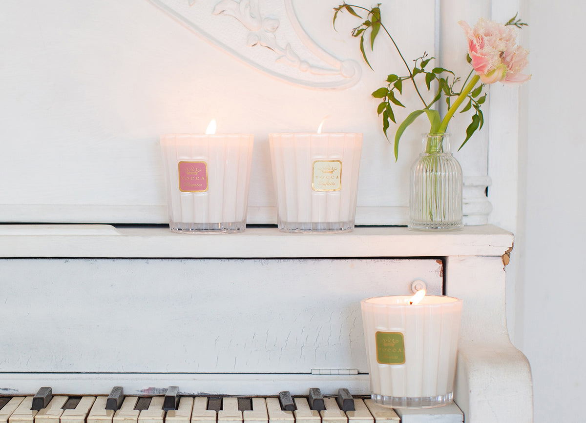 TOCCA candles sitting on top of a piano